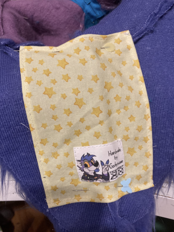 Der bedruckte Stoff ist am Hals des fertigen Fursuit-Kopfes festgesteckt.