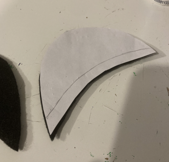 Dieselbe Papiervorlage liegt diesmal mit einer nach unten verlaufenden Linie auf der Basis des Augenlids